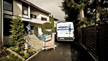 Mitarbeiter trägt Teppich von einer Entrümpelung aus dem Haus